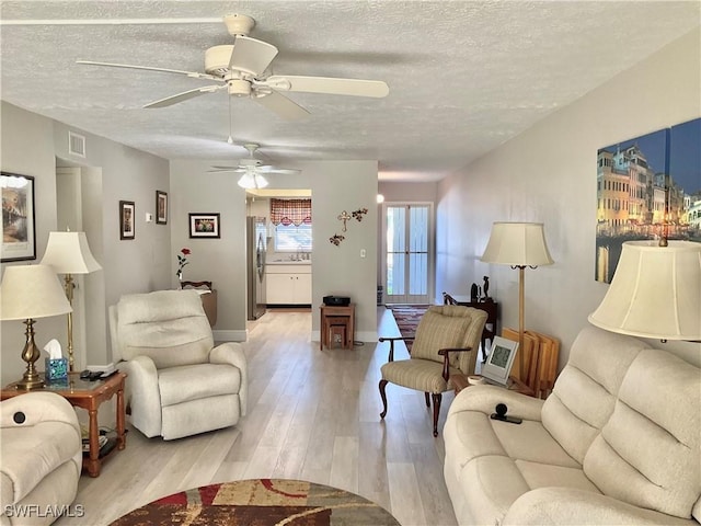 living room featuring a textured ceiling and light hardwood / wood-style floors