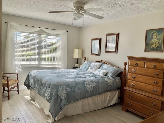 bedroom featuring ceiling fan, a textured ceiling, and light wood-type flooring