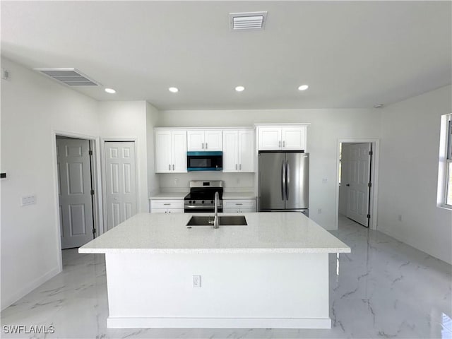 kitchen featuring stainless steel appliances, sink, a center island with sink, and white cabinets