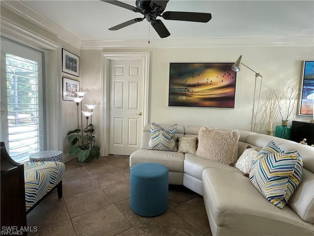 living room with ceiling fan, ornamental molding, and dark tile patterned floors