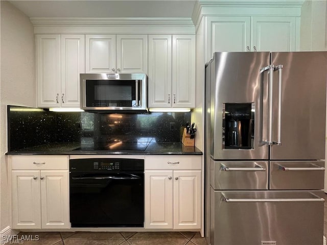 kitchen featuring dark tile patterned flooring, white cabinets, backsplash, and black appliances