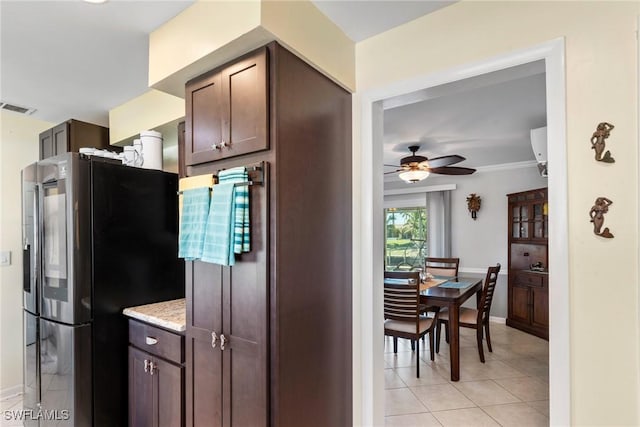 kitchen featuring light tile patterned floors, ceiling fan, dark brown cabinetry, light stone counters, and stainless steel refrigerator with ice dispenser