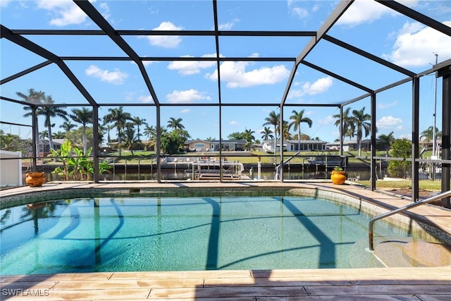 view of swimming pool featuring a patio, a water view, and glass enclosure