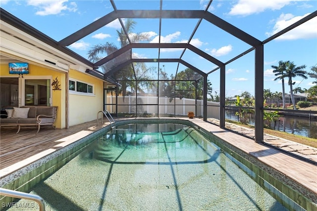 view of pool with an outdoor living space, a water view, and glass enclosure