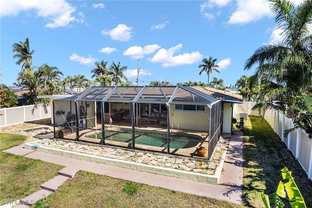 back of property featuring a yard, a lanai, a fenced in pool, and a patio area