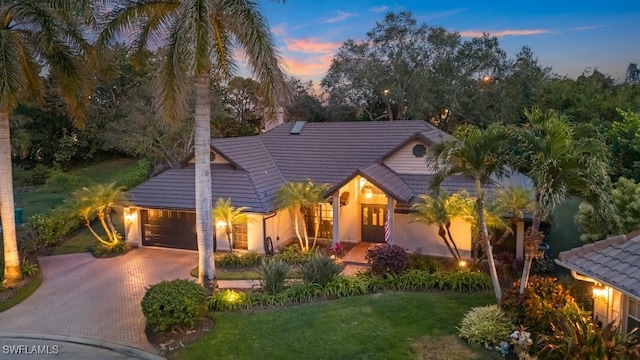 view of front of property with a garage and a lawn