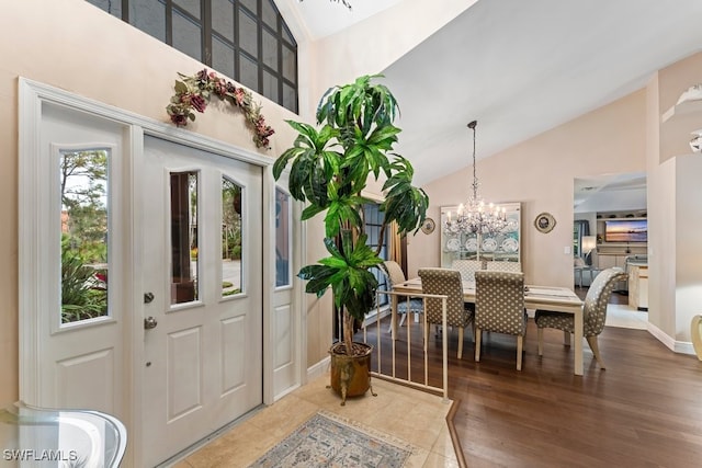 entrance foyer featuring a notable chandelier, wood-type flooring, and high vaulted ceiling