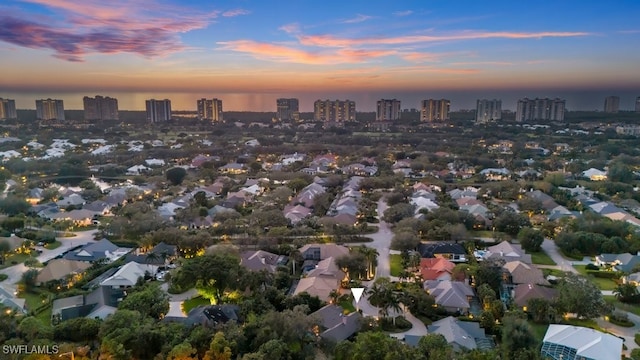 aerial view at dusk featuring a water view