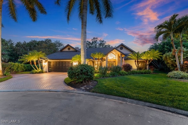 view of front of home featuring a garage and a yard