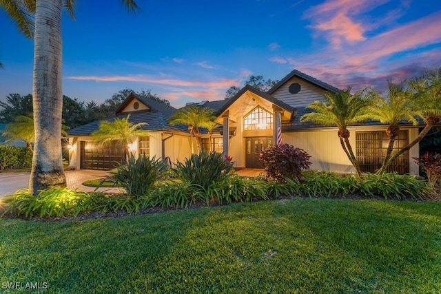 view of front of home featuring a garage and a yard