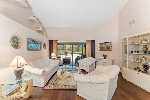 living room featuring dark hardwood / wood-style flooring and high vaulted ceiling