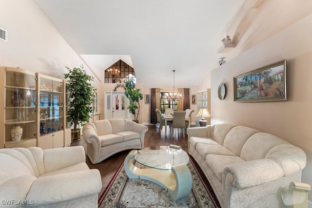 living room with lofted ceiling, a notable chandelier, and hardwood / wood-style floors