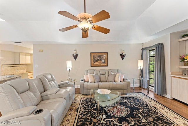 living room featuring ceiling fan, a tray ceiling, and hardwood / wood-style floors