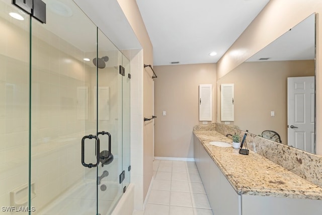 bathroom featuring tile patterned flooring, vanity, and bath / shower combo with glass door