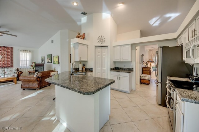 kitchen with light tile patterned flooring, sink, range with two ovens, and white cabinets