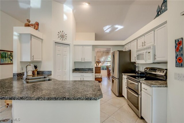 kitchen with a kitchen bar, sink, kitchen peninsula, stainless steel appliances, and white cabinets