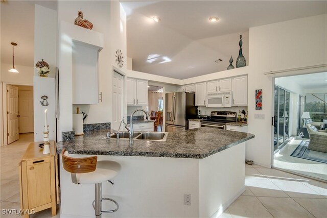 kitchen featuring sink, light tile patterned floors, stainless steel appliances, white cabinets, and kitchen peninsula