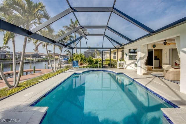 view of swimming pool featuring a patio, glass enclosure, and a water view