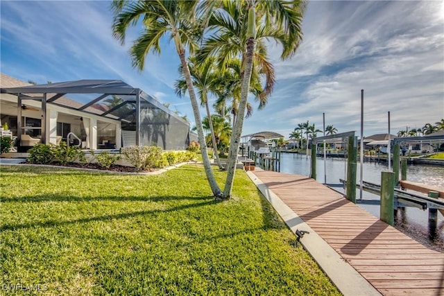 dock area with a water view, glass enclosure, and a lawn