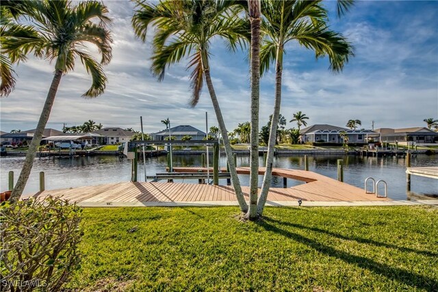 dock area with a water view and a yard