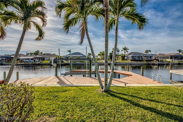 view of dock with a water view and a lawn