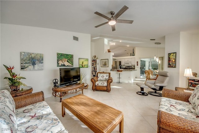 living room featuring vaulted ceiling, light tile patterned floors, and ceiling fan