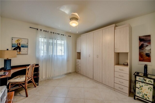 home office with light tile patterned floors and ceiling fan