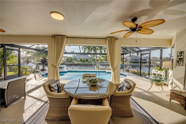 sunroom / solarium with a water view, a pool, and ceiling fan