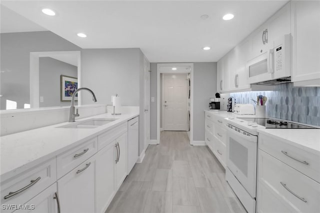 kitchen with sink, white cabinetry, white appliances, light stone countertops, and decorative backsplash