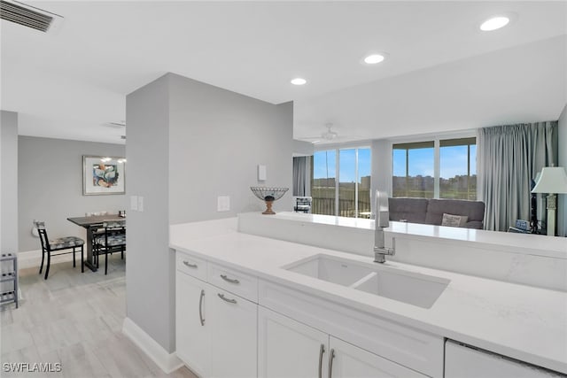 kitchen with sink, white cabinets, and ceiling fan