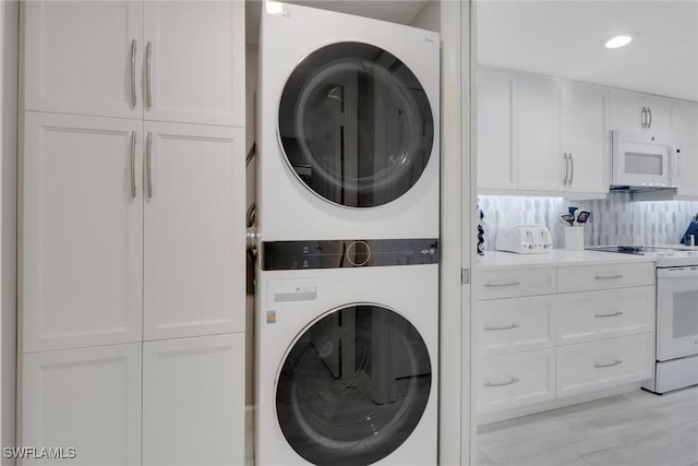 washroom featuring stacked washer and clothes dryer