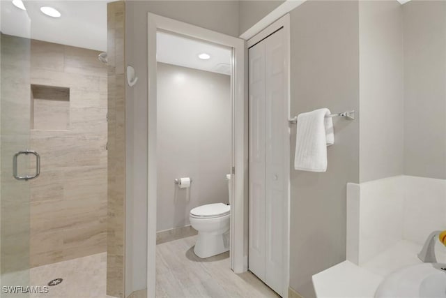 bathroom with an enclosed shower and toilet