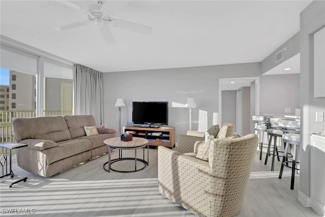 living room with ceiling fan and light hardwood / wood-style floors