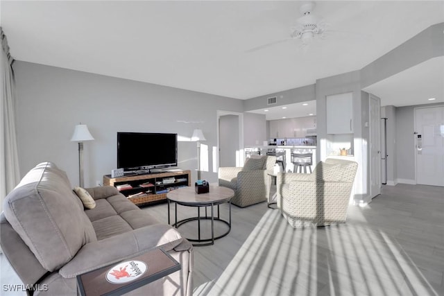 living room with ceiling fan and light wood-type flooring