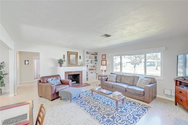 living room featuring a brick fireplace and a textured ceiling