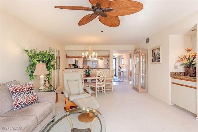 living room with ceiling fan with notable chandelier and light colored carpet