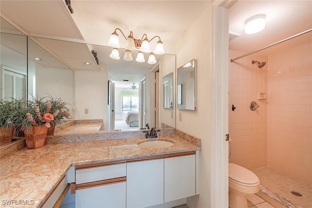 bathroom with vanity, toilet, and a tile shower