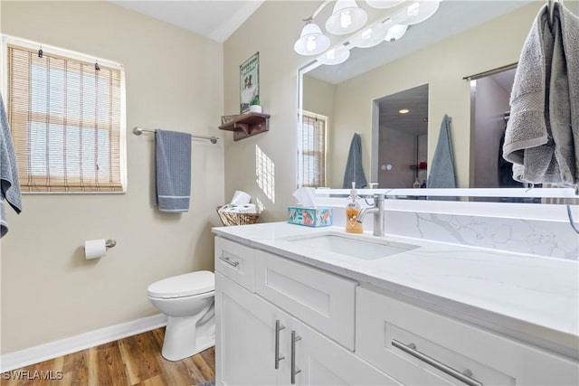 bathroom featuring vanity, hardwood / wood-style floors, toilet, and a healthy amount of sunlight