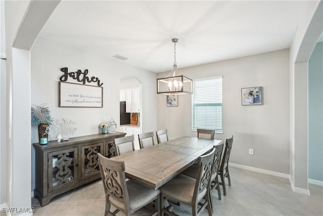 tiled dining area with a chandelier