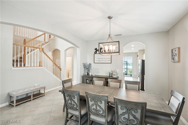 dining area with light tile patterned flooring and a notable chandelier