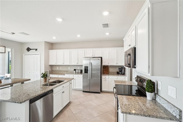 kitchen featuring light stone counters, sink, white cabinets, and appliances with stainless steel finishes