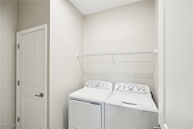 clothes washing area with separate washer and dryer