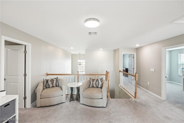 sitting room featuring light carpet and plenty of natural light