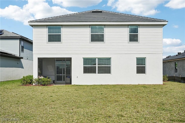 rear view of house featuring a lawn