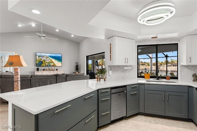 kitchen featuring tasteful backsplash, white cabinetry, lofted ceiling, gray cabinetry, and kitchen peninsula