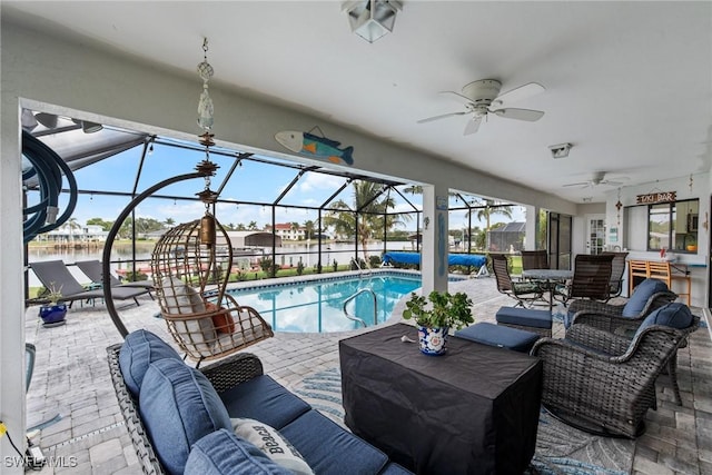 view of pool with an outdoor living space, a lanai, ceiling fan, and a patio area