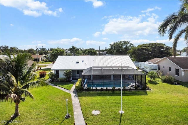 back of property with glass enclosure and a lawn