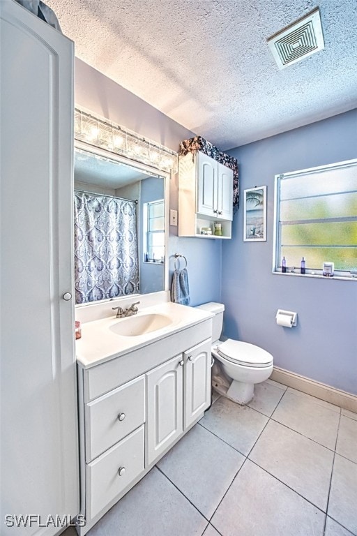 bathroom with vanity, tile patterned floors, toilet, and a textured ceiling