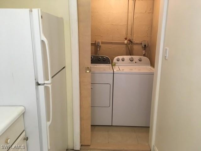 laundry room with light tile patterned flooring and washing machine and clothes dryer