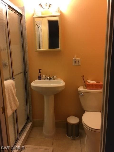 bathroom with toilet, tile patterned floors, and walk in shower